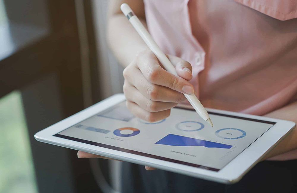 En kvinnelig hånd som trykker på en laptop.