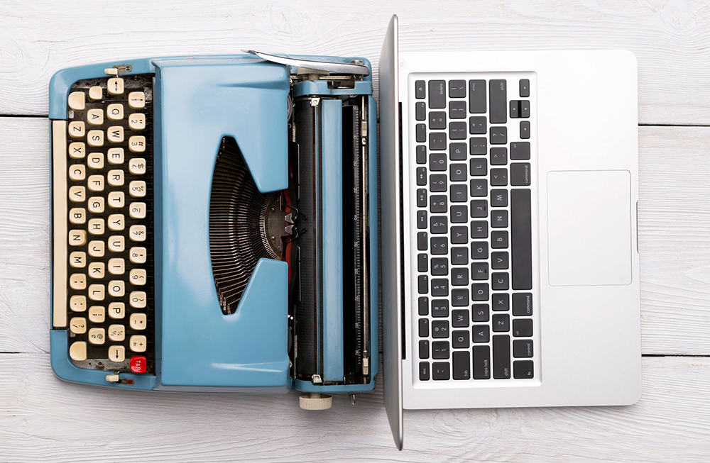 En skrivemaskin og en laptop på hver sin side som illustrerer digitalisering da det ser ut som om skrivemaskinen forvandler seg til en laptop.